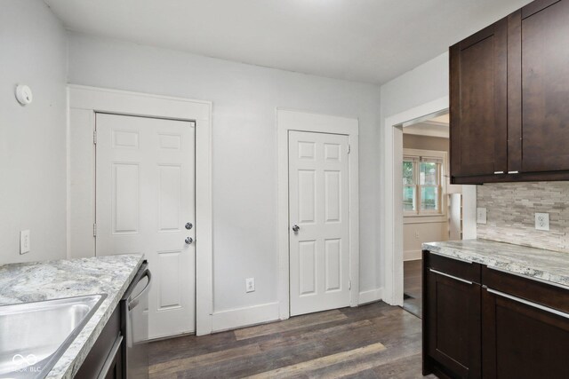 kitchen featuring decorative backsplash, dark brown cabinets, dark hardwood / wood-style floors, and light stone countertops