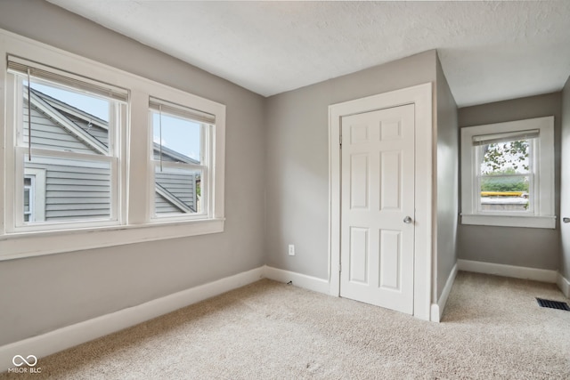 unfurnished bedroom featuring carpet floors and a textured ceiling