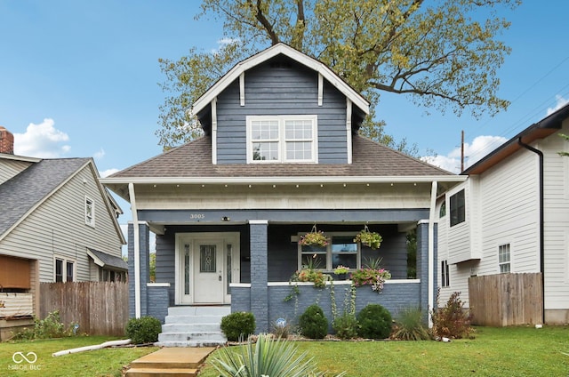 3005 Broadway St, Indianapolis, IN 46205 - view of front facade with fence, a front lawn, a porch, and roof with shingles