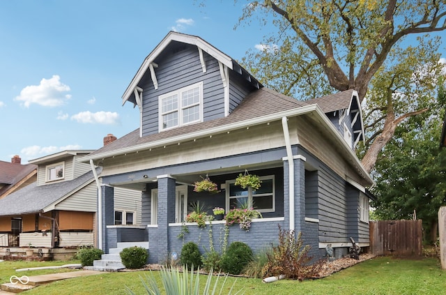 view of front facade with a front yard and covered porch