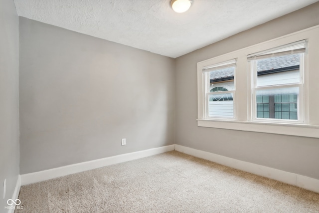 spare room with a textured ceiling and carpet