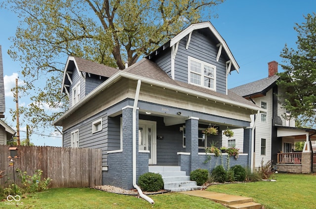 view of front of house with a front yard and covered porch