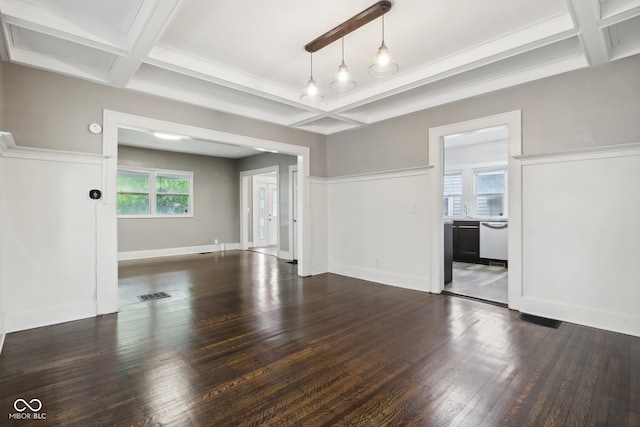 unfurnished living room featuring a healthy amount of sunlight, dark hardwood / wood-style flooring, and beamed ceiling