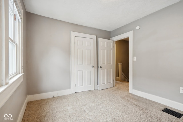 unfurnished bedroom featuring light colored carpet