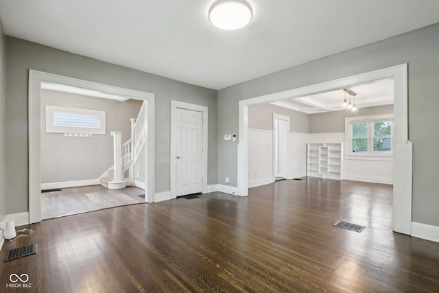 unfurnished living room with dark wood-type flooring