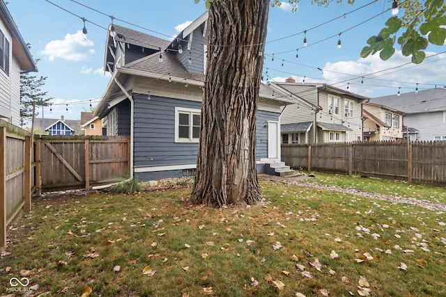 3005 Broadway St, Indianapolis, IN 46205 - rear view of house featuring roof with shingles, a fenced backyard, a residential view, entry steps, and a lawn