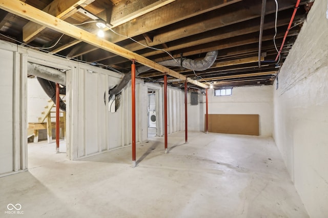 basement featuring electric panel and washer / dryer