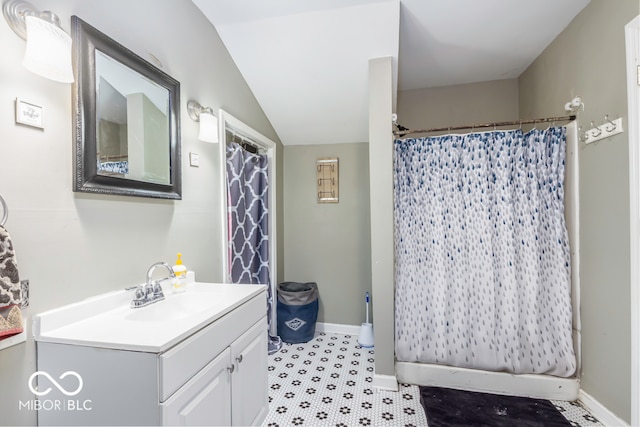 bathroom featuring a shower with curtain, vaulted ceiling, and vanity