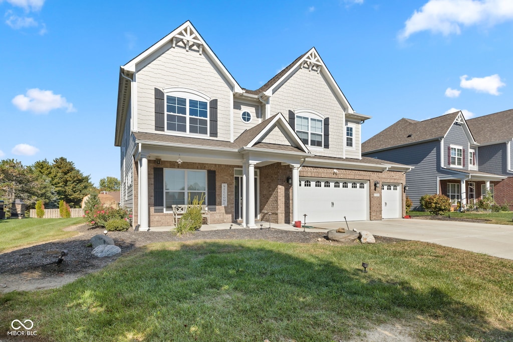 1220 Greenwood Station Blvd, Greenwood, IN 46143 - view of front of home featuring a front yard, covered porch, a garage, driveway, and brick siding