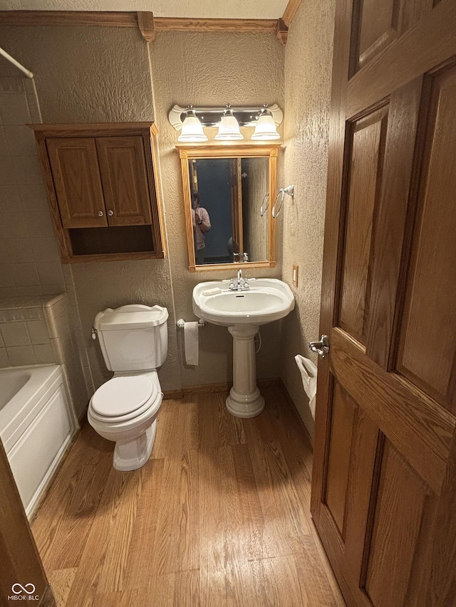 8855 N Waverly Park Rd, Martinsville, IN 46151 - bathroom featuring shower / bathing tub combination, wood finished floors, toilet, and a textured wall