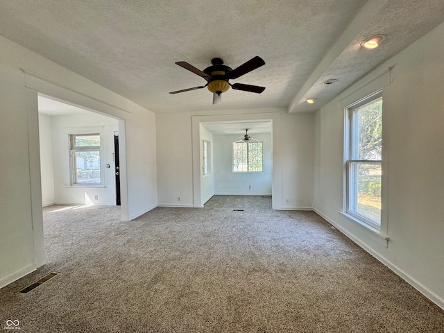 unfurnished room featuring carpet, ceiling fan, and a textured ceiling