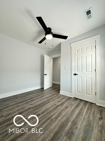 unfurnished bedroom with dark wood-type flooring and ceiling fan