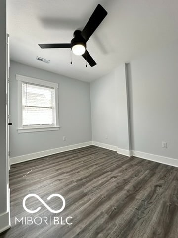 spare room with ceiling fan and dark hardwood / wood-style floors