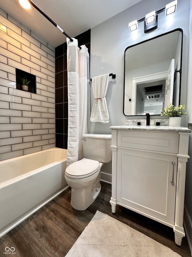 full bathroom featuring hardwood / wood-style flooring, vanity, shower / bath combo, and toilet