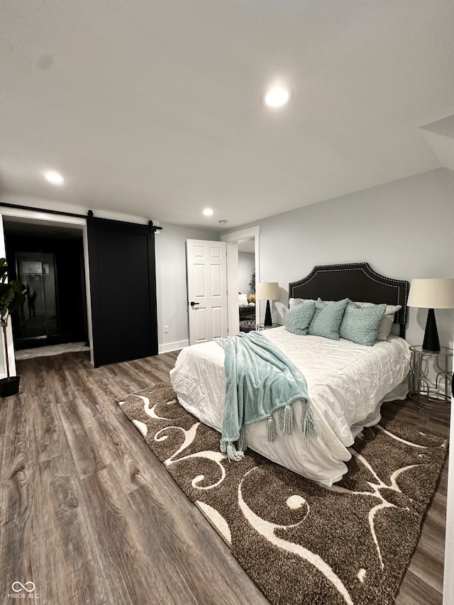 bedroom featuring hardwood / wood-style flooring and a barn door