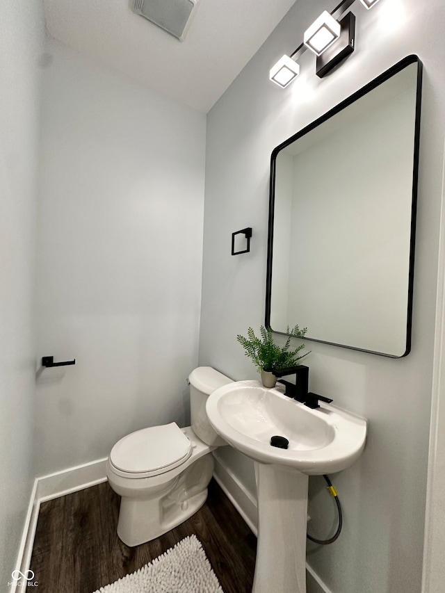 bathroom featuring hardwood / wood-style flooring and toilet