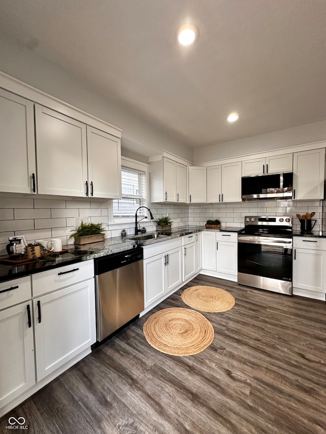 kitchen with dark hardwood / wood-style floors, white cabinetry, sink, and appliances with stainless steel finishes