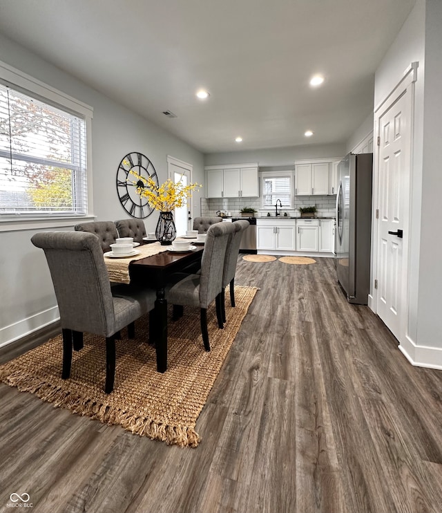 dining space with dark hardwood / wood-style floors and sink