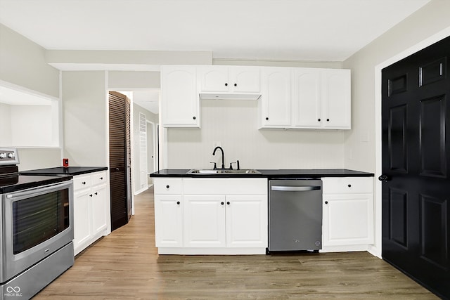 kitchen with light wood-type flooring, white cabinetry, appliances with stainless steel finishes, and sink