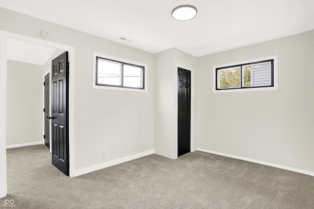 unfurnished room featuring light colored carpet and a wealth of natural light