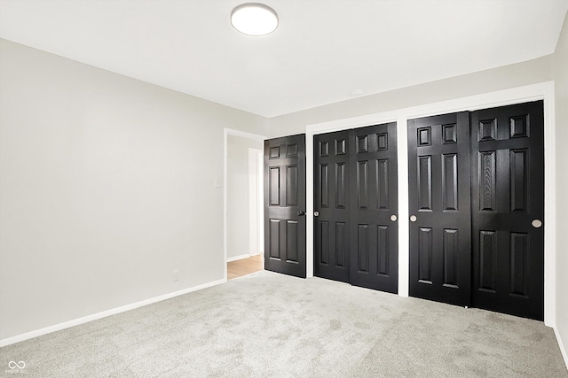 unfurnished bedroom with light colored carpet and multiple closets