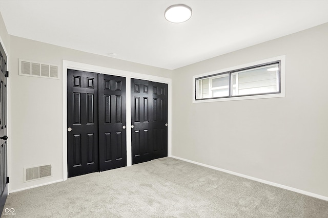 unfurnished bedroom with carpet floors and multiple closets