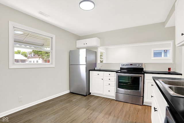 kitchen featuring appliances with stainless steel finishes, light wood-type flooring, sink, and white cabinetry