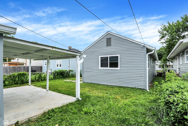 view of side of property featuring a yard and a patio area