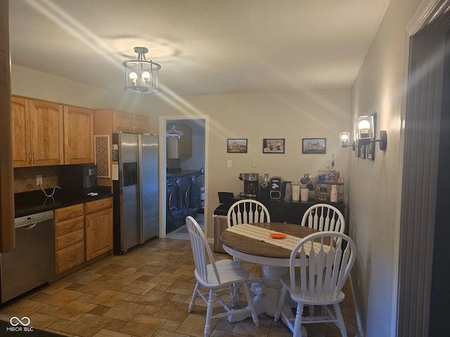 dining space with washer / clothes dryer and a chandelier