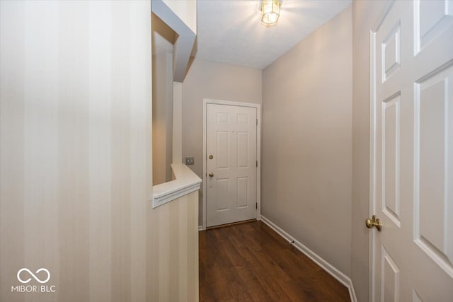 hall with a textured ceiling and dark hardwood / wood-style flooring