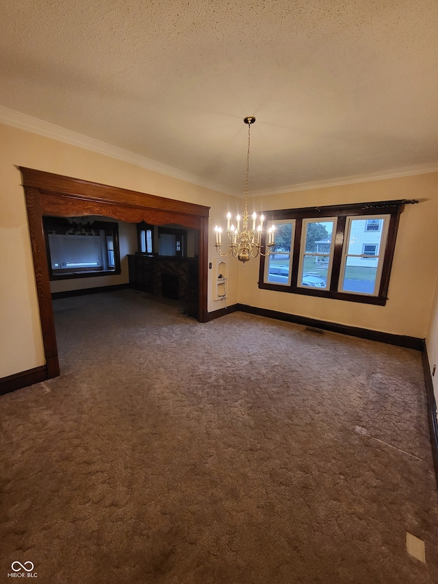 unfurnished dining area featuring an inviting chandelier, crown molding, dark colored carpet, and a textured ceiling