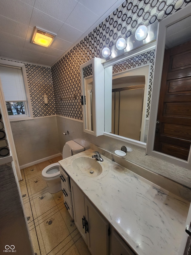 bathroom with vanity, toilet, and a shower with door