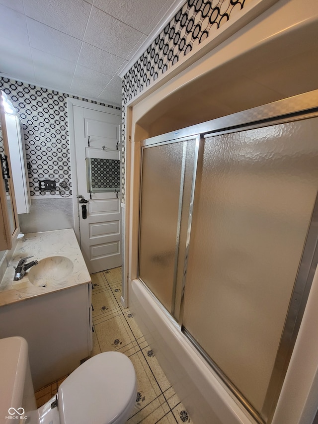 full bathroom featuring bath / shower combo with glass door, vanity, and toilet