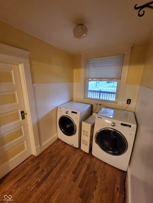 clothes washing area with washing machine and dryer and dark hardwood / wood-style flooring