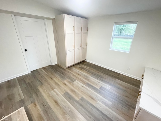 unfurnished bedroom with a closet and hardwood / wood-style flooring