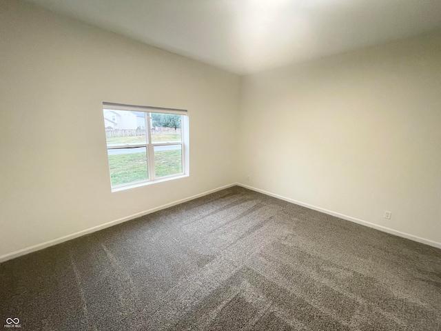 carpeted empty room featuring lofted ceiling