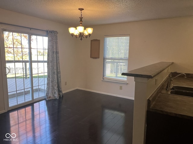 dining room featuring a healthy amount of sunlight, sink, and dark wood-type flooring