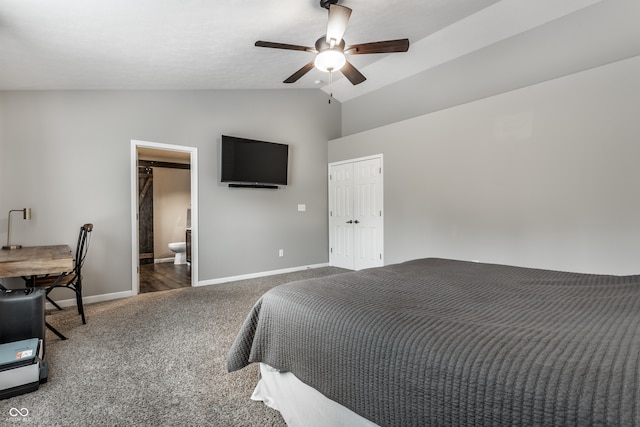 bedroom with connected bathroom, vaulted ceiling, dark colored carpet, and ceiling fan