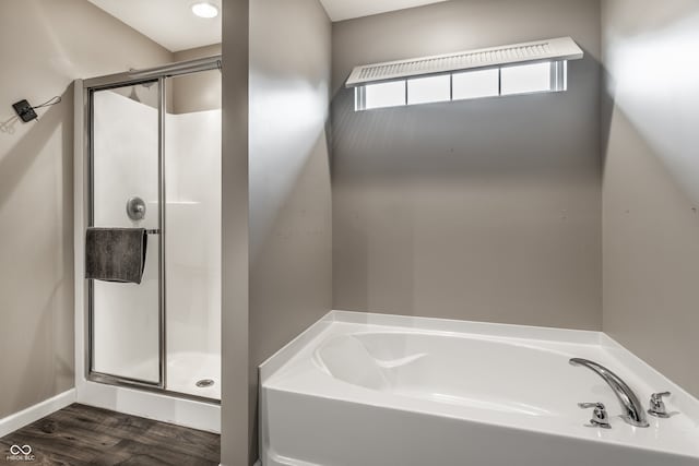 bathroom with independent shower and bath and hardwood / wood-style flooring