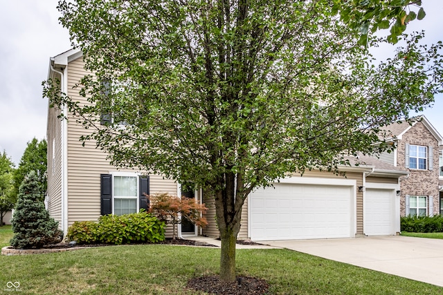 obstructed view of property featuring a front yard and a garage