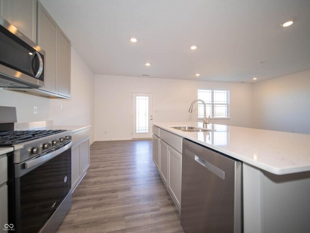 7888 Magnolia St, New Palestine, IN 46163 - kitchen with appliances with stainless steel finishes, wood finished floors, recessed lighting, gray cabinetry, and an island with sink
