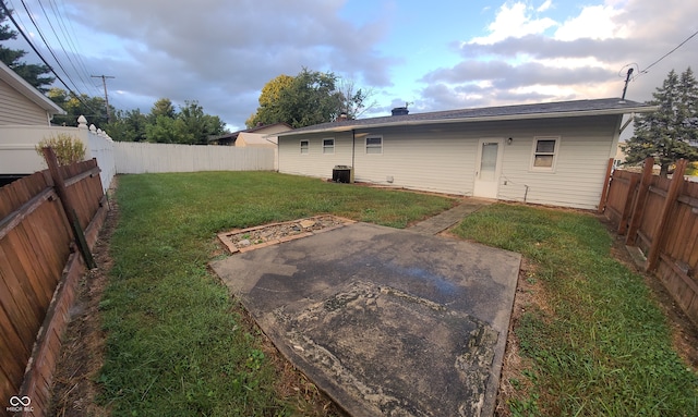 back of property with a yard, a patio area, and central air condition unit