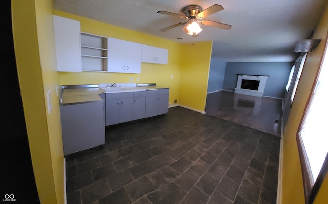 kitchen featuring ceiling fan and white cabinets