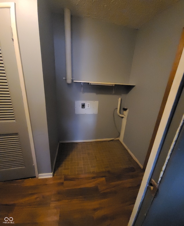 laundry area with hookup for a washing machine, a textured ceiling, and dark hardwood / wood-style floors