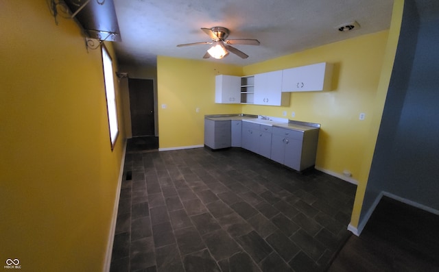 kitchen with white cabinets, ceiling fan, and sink