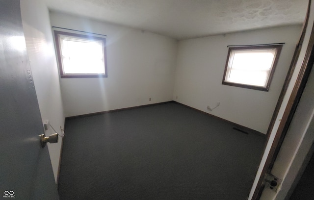 unfurnished room featuring a textured ceiling