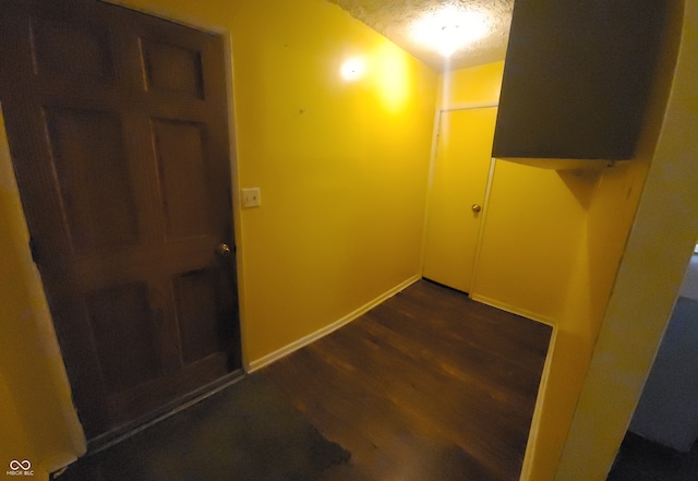 hallway featuring a textured ceiling and dark hardwood / wood-style flooring