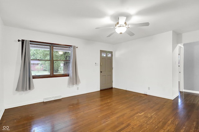 spare room with dark wood-type flooring and ceiling fan