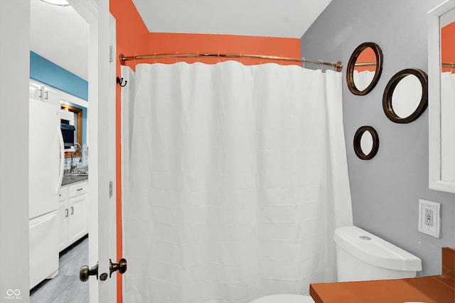 bathroom with curtained shower and toilet