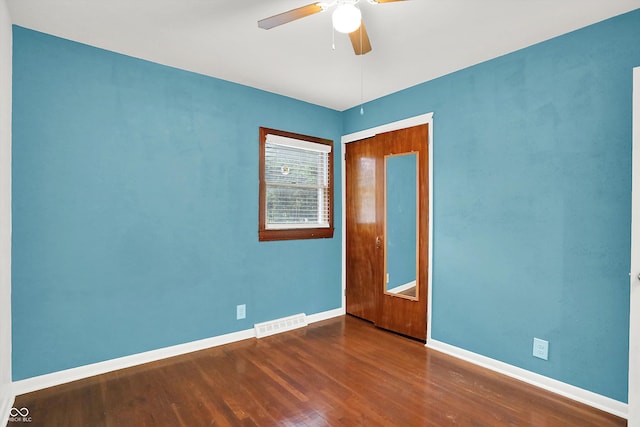 unfurnished room with ceiling fan and dark wood-type flooring